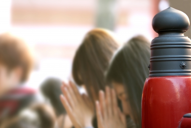 神社で手を合わせる人々