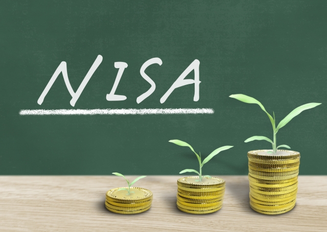 NISAと書かれた黒板と、積み立てたコインから出た芽